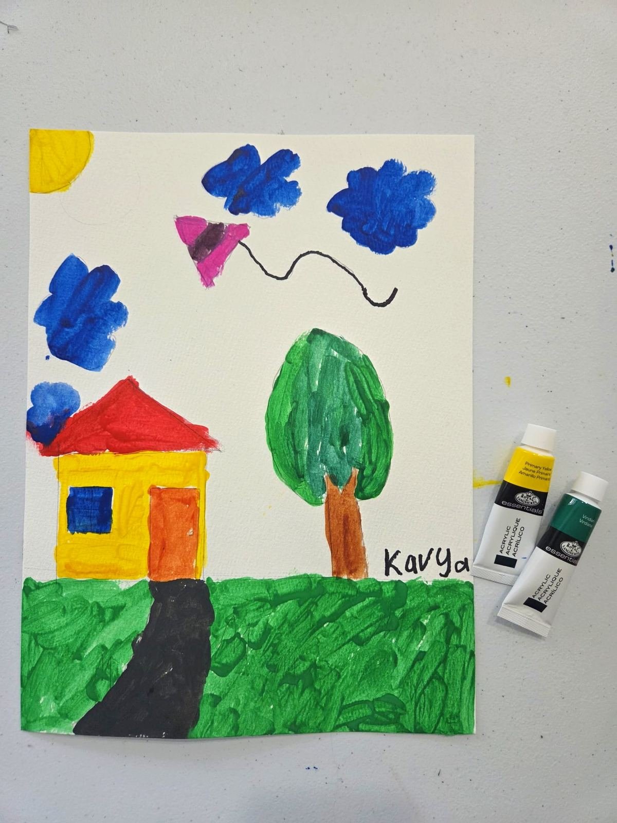 Student painting of a house and tree, signed Kavya
