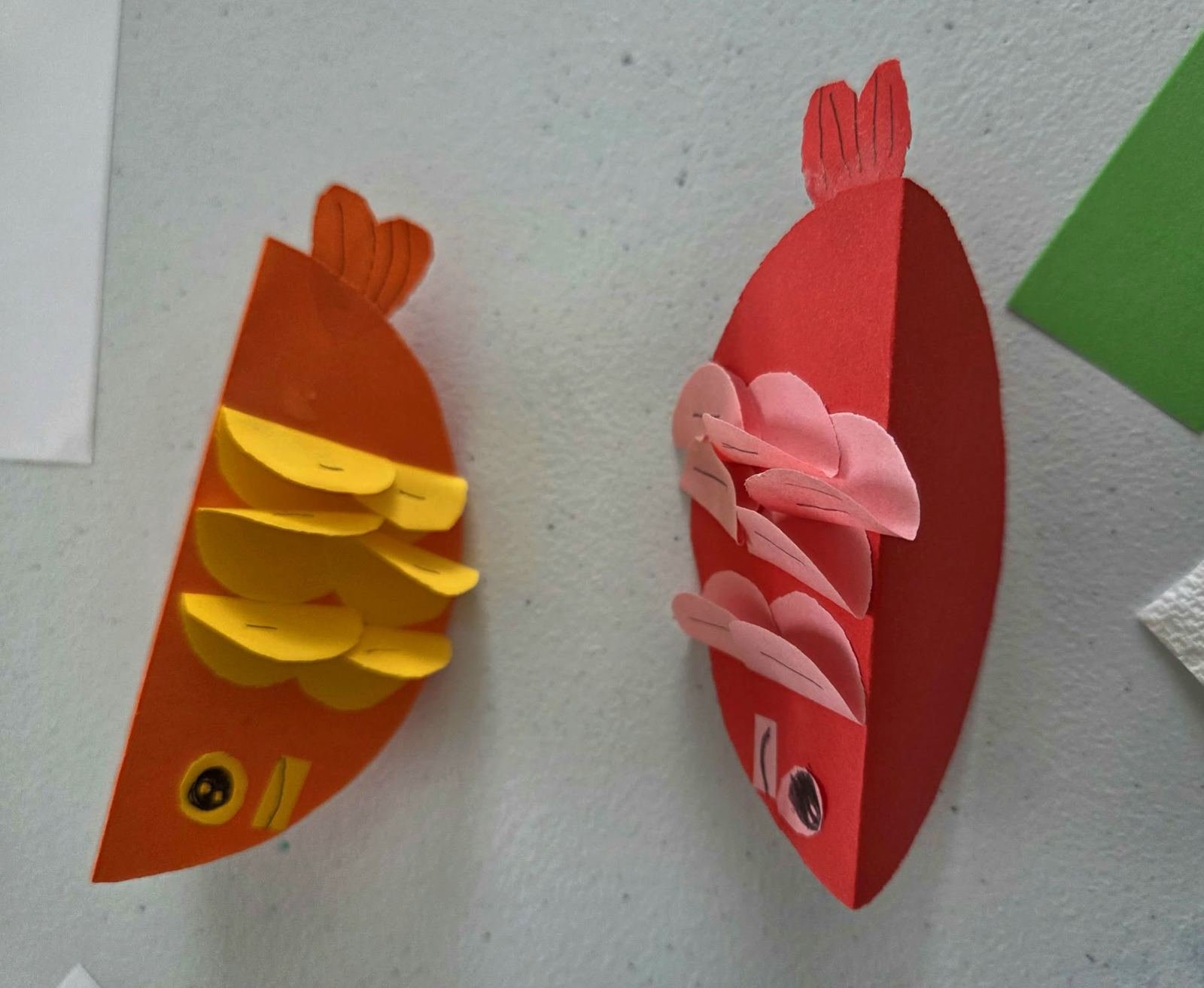 Student Paper Hand Craft — paper fish and caterpillar creations on the craft table